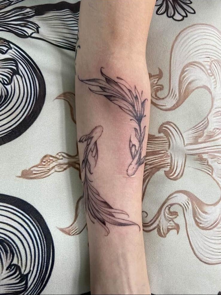 Fine-Line Fische Tattoo am Unterarm